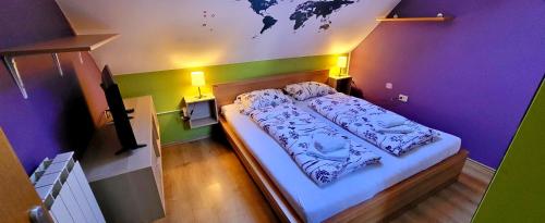 博维茨Simonai Apartment的紫色和绿色墙壁间的一张床