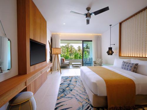 马埃岛laïla, Seychelles, a Marriott Tribute Portfolio Resort的酒店客房设有床、电视和客厅。