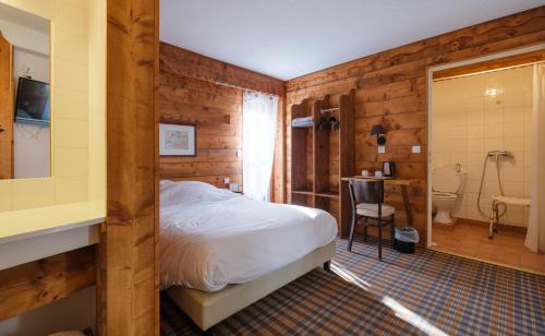 香槟沙隆Cit'Hotel Le Montreal的一间带木墙和一张床的卧室以及一间浴室。