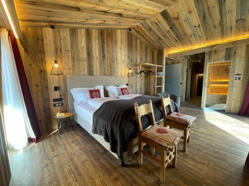 利维尼奥皮克洛西藏酒店的一间卧室设有一张大床和木墙