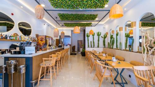 米拉斯Cabana Boutique Hotel & Cafe的一间带桌椅的餐厅和一间酒吧