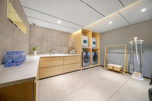 哈尔滨哈尔滨高铁西站亚朵X酒店的洗衣房配有水槽和2台洗衣机