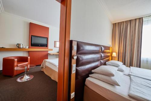 埃森佈雷登尼酒店的配有一张床和一把椅子的酒店客房