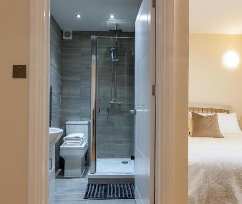 布拉克内尔Charnwood Guest House的带淋浴和卫生间的浴室以及1张床。