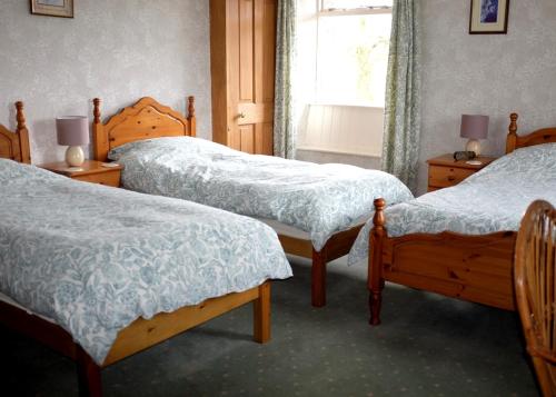 柯比朗斯代尔Ullathorns Farm的一间卧室设有三张床和窗户。
