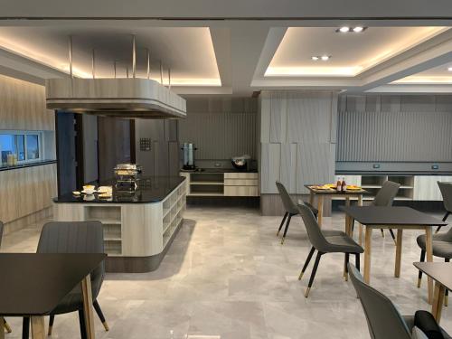 曼谷Thana Wisut Hotel - SHA Plus的大型厨房以及带桌椅的用餐室