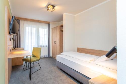 波滕施泰因施万酒店的一间卧室配有一张床、一张桌子和一把椅子