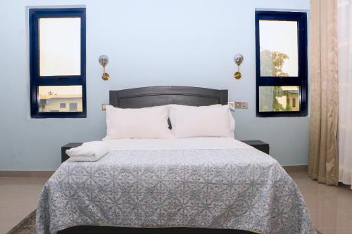 林贝Candide Guest House的一间卧室设有一张床和两个窗户。