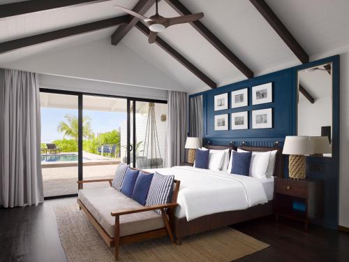 北马累环礁Villa Nautica Paradise Island Resort的一间卧室配有一张带蓝色墙壁的大床