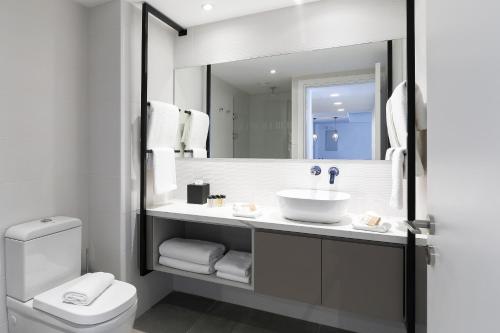 沃罗里尼The Quality Lodge - Self Check-in的一间带水槽、卫生间和镜子的浴室