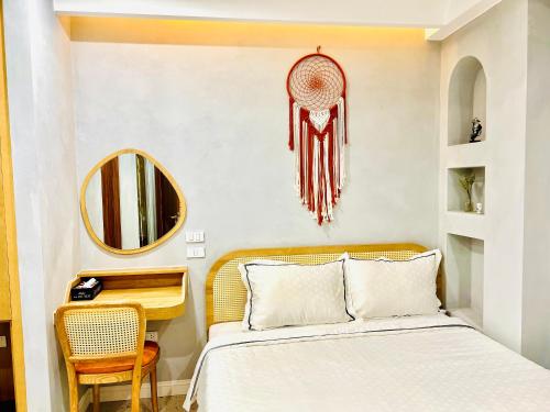 富国Rova Hotel Phú Quốc的一间卧室配有一张床、一张书桌和一面镜子