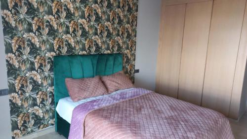 卡萨布兰卡Maarif的一间卧室配有一张带绿色床头板的床
