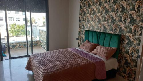 卡萨布兰卡Maarif的一间卧室配有一张带绿色床头板的床