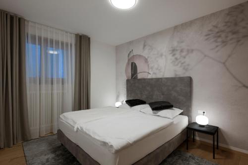 思科纳Mair Appartements in Schenna的卧室设有一张白色大床和一扇窗户。