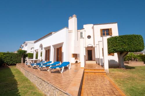 马略卡岛帕尔马Casa Felix的白色的房子,在庭院里设有蓝色的椅子