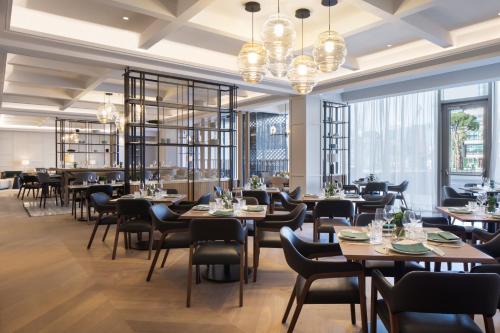 地拉那Tirana Marriott Hotel的餐厅设有桌椅和窗户。