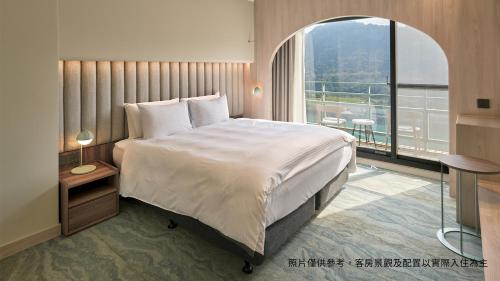 龙潭福华石门水库渡假饭店 的一间卧室设有一张大床和一个大窗户