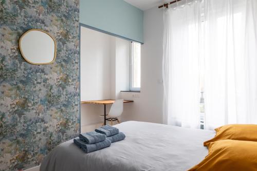 坎佩尔Appartement spacieux的一间卧室配有一张带蓝色毛巾的床