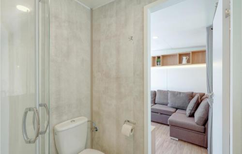 普莱因费尔德Tiny Haus 75 Am Brombachsee的一间带卫生间的浴室和一张沙发。