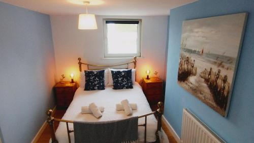 布里克瑟姆Pearl Cottage with parking pass - Grade II listed的一间卧室配有一张带两个枕头的床