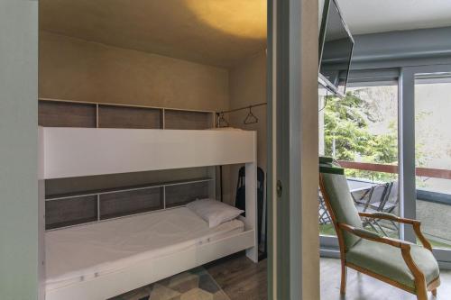巴里吉斯L'Esquiròu - Proche pistes pour 6的一间小卧室,配有双层床和椅子