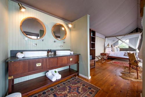 阿多Camp Figtree by The Oyster Collection的一间带水槽的浴室和一张位于客房内的床