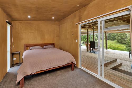 凯里凯里Waimate Farmstay - Kerikeri Holiday Home的一间卧室设有一张床和一个阳台