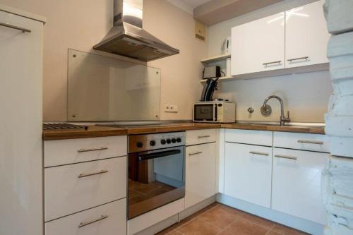 蒂宾根Ruhige 2-Zimmer Wohnung m.Terrasse,Nähe Uni-Klinik的厨房配有白色橱柜和炉灶烤箱。