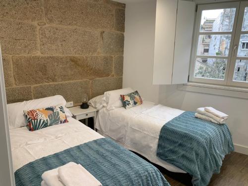 庞特维德拉Casa Cousiño Zona Monumental的一间卧室设有两张床和砖墙