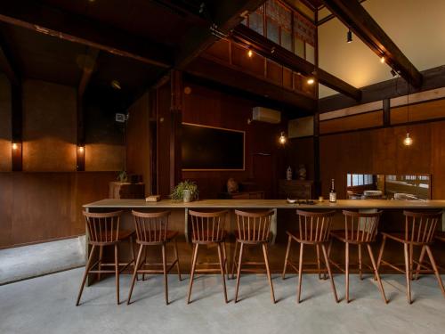 长滨市Hitoiki的厨房设有环绕着椅子的酒吧