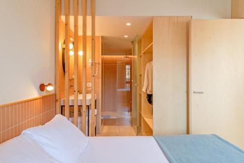 巴塞罗那Jardinets De Gràcia by The 5ve Soul的一间卧室设有一张床和一个步入式淋浴间。