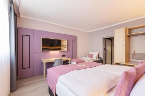 柏林Yggotel Spurv的一间卧室设有紫色的墙壁、一张床和一张书桌
