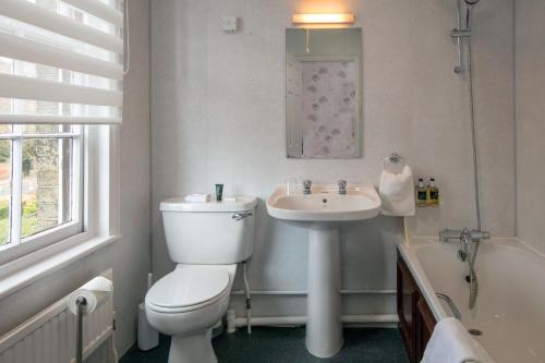 诺里奇安妮丝雷贝斯特韦斯特酒店的浴室配有卫生间、盥洗盆和浴缸。