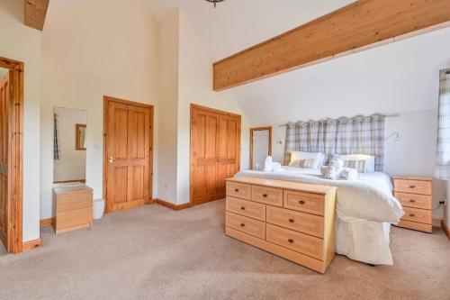 特鲁罗3 bed Lodge with EV point的一间大卧室,配有一张大床和木制橱柜