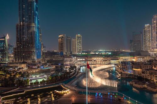 迪拜Elite Royal Apartment - Full Burj Khalifa & Fountain view - Ambassador的城市天际线,夜晚有高楼
