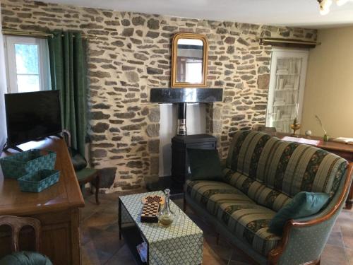 圣詹姆斯Le cottage normand的带沙发和石墙的客厅