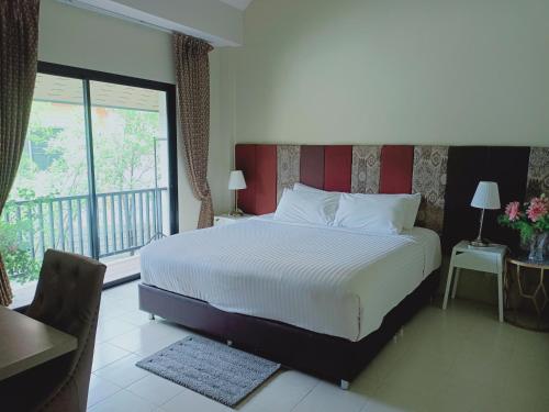 清迈斯里拿各昌酒店的一间带大床的卧室和一个阳台