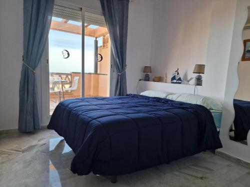 马拉加Atardecer de ensueño的一间卧室配有一张带蓝色毯子的床