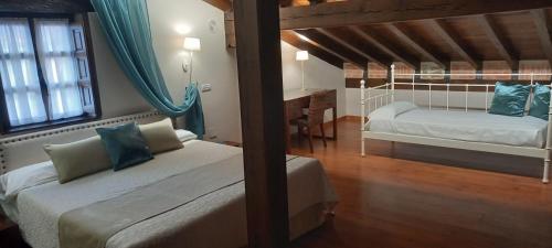 桑提亚纳德玛雷沃格卡索娜酒店的一间卧室配有两张床和一张书桌