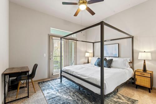 奥斯汀Spacious 2BR King Bed Suites Close to Downtown and Airport的一间卧室配有一张带吊扇的床和一张书桌。