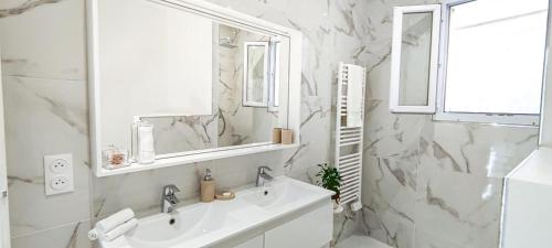 拉蒂尔比耶Villa Palmire, large terrace with jacuzzi available的白色的浴室设有水槽和镜子