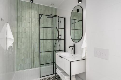波兹南Apartament Aleja 22的带淋浴、盥洗盆和镜子的浴室