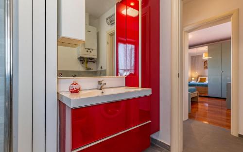 普拉Apartment Green Pula, Family friendly, Comfortable, free parking and WiFi的一间带红色橱柜和水槽的厨房