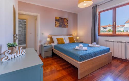 普拉Apartment Green Pula, Family friendly, Comfortable, free parking and WiFi的一间卧室配有一张带蓝色床单和黄色枕头的床。
