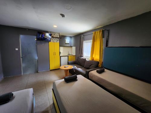 埃拉特Amdar Hostel的一间带两张床和一张沙发的客厅