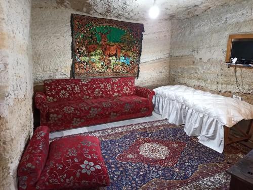于尔居普CAVE HOUSE(KIR EVİ)的客厅配有红色沙发和地毯。