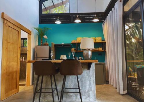 诺萨拉Casita Vinita的厨房设有带2张凳子和绿色墙壁的酒吧