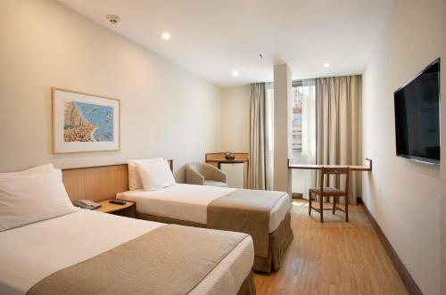 里约热内卢温莎广场科帕卡巴纳酒店的酒店客房设有两张床和一台平面电视。