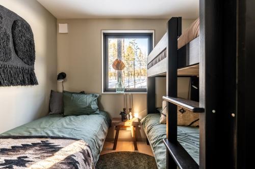 伊德菲尔Nybyggda parhus i Idre的一间卧室设有两张双层床和一扇窗户。