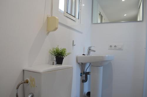 安波拉Casa Mar i Sol的一间带水槽和白色冰箱的浴室